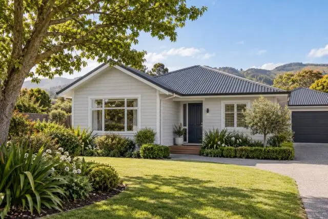 Weatherboard family home with a charcoal roof and a landscaped spring garden